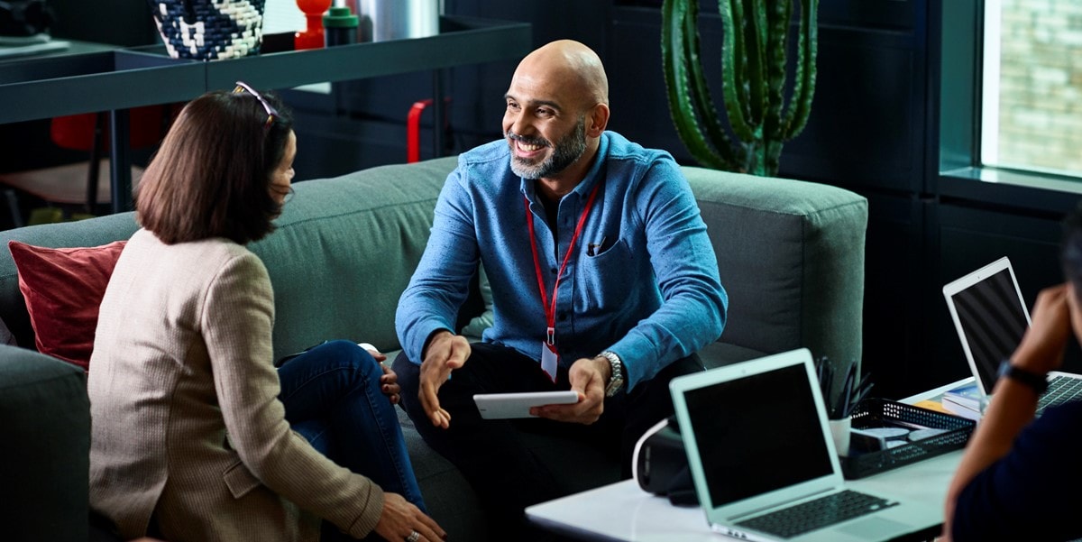 two professionals in office meeting, sitting on couch