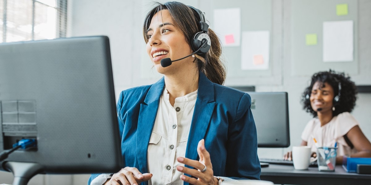 woman in office, working at desk, wearing headset