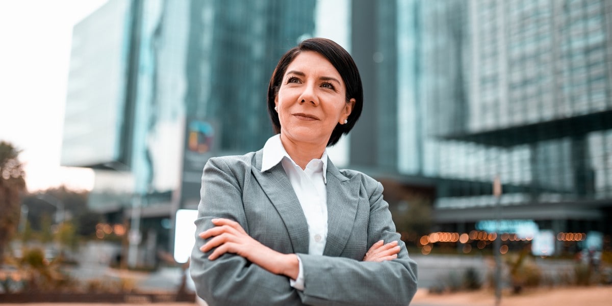 professional woman standing outside building with arms crossed