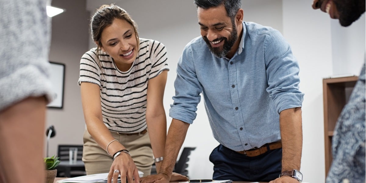 two people working on a laptop, smiling