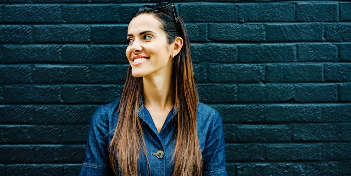 mujer sonriendo frente pared azul