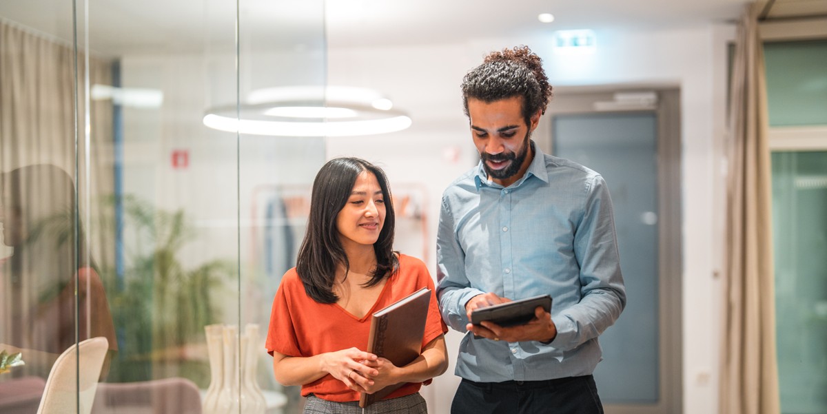 two people in the office reviewing something on a tablet