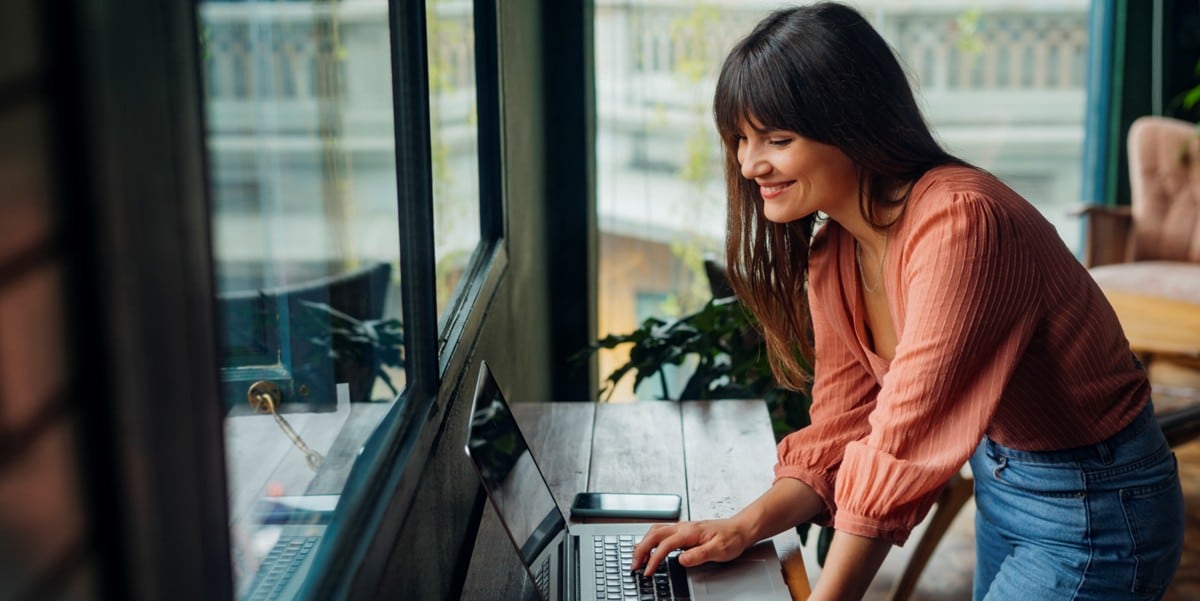 woman smiling, working at a desk