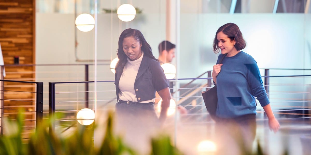 two professional women walking through the office