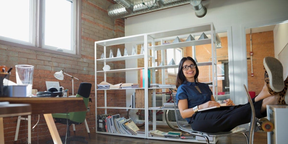 mujer sentada en oficina sonriendo